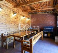 Wooden terrace in a family house with a wooden decor and a brick wall.