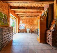 Interior of a family house with wooden walls, a tiled stove, and artistic paintings.