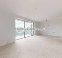 A bright room with large windows, a floor with a wooden decor.