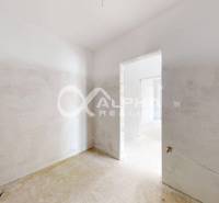 Unfinished interior in a 3-room apartment with plastered walls and preparation for installations.