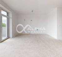 A bright room with a large window and a balcony in a 3-room apartment, white walls.