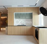 A kitchen with a wood-patterned floor and built-in appliances in a 3-room apartment.