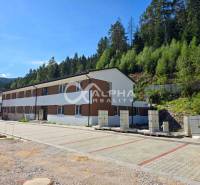 An apartment complex in Spišská Nová Ves surrounded by greenery, with paved parking areas in front of the building.