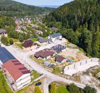 An aerial view of a small village surrounded by forests near Spišská Nová Ves.