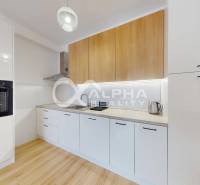 A kitchen in a 2-room apartment with a wooden decor floor and modern appliances.