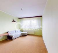 A room in a 3-room apartment with a sofa, a table, and light green walls.