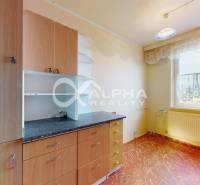 A kitchen in a 3-room apartment with a floating floor and a window with a radiator.