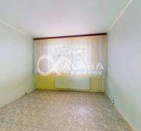 An empty room with linoleum in a 3-room apartment, view from the window through curtains.