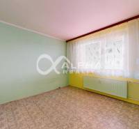 A room in a 3-room apartment with light walls and a window with a white curtain.