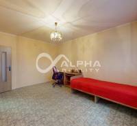 A room in a 3-room apartment with a chandelier, a single bed, and a desk.