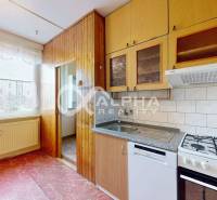 A kitchen with a stove and wooden decor in a 3-room apartment.