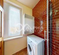 Washing machine next to the window, wall tiles in the apartment.