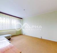 Living room in a 3-room apartment with a sofa, table, and curtains on the window.