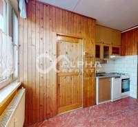 A kitchen in a 3-room apartment with a kitchen unit and a floor with a wooden decor.