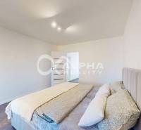 Bedroom in a two-room apartment with a bed and a wooden decor floor.