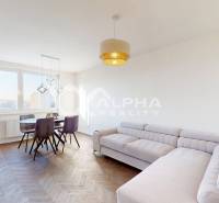 Living room in a two-room apartment with a light-colored sofa and a dining table.