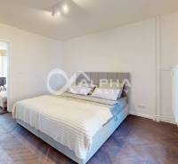 A bedroom with a comfortable bed and a wooden decor floor in a two-room apartment.