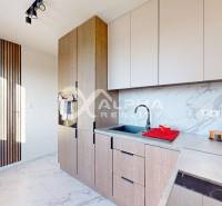 A kitchen in a 2-room apartment with wooden paneling and a marble countertop.
