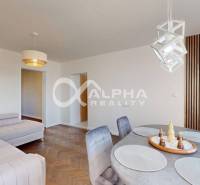 Living room with wood-patterned flooring, a corner sofa, and a dining table in a two-room apartment.