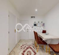 Dining room in a 2-room apartment with a beige carpet and brown chairs.