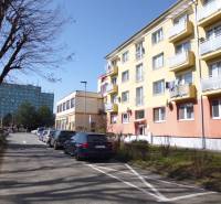 17th November Street in Prešov with apartment buildings and parked cars, suitable for a 1-room apartment.