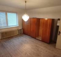 A room with wooden decor, a wardrobe, and a window in a family house.