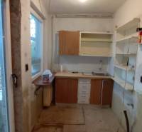 A kitchen in a family house with incomplete renovation and storage space.