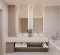 A bathroom with two sinks, a bathtub, and decorative lighting in a 3-room apartment.