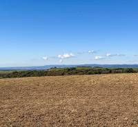 Extensive agricultural and forest lands near Lackov with a panoramic view of the hills.