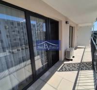 The balcony of a 2-room apartment on Eduarda Wenzla Street in Bratislava - Rača with glass doors.