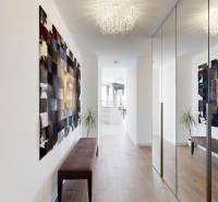 A hallway in a 3-room apartment with a wooden decor floor and a mirrored wardrobe.