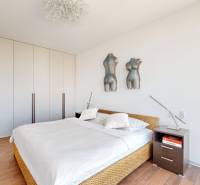 Bedroom with a bed, built-in wardrobe, and wooden decor flooring in a 3-room apartment.
