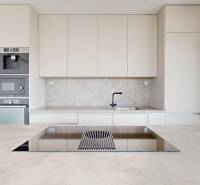A modern kitchen in a 3-room apartment with white cabinets and built-in appliances.