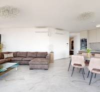 Living room in a 3-room apartment with a corner sofa, glass table, and dining table.