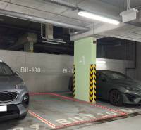 Parking space in garages with two cars, illuminated by fluorescent lights and marked BII-130.