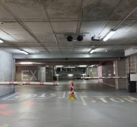 Parking lot in a garage with concrete walls, ramps, and signs Exit and Stop.