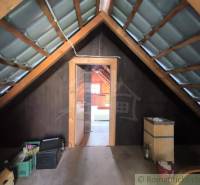 The attic of a cottage with wooden decor, view through the open entrance.
