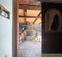View from the cottage to the outdoor oven and yard with wood in Hronská Dúbrava.