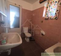 A bathroom in a cabin with basic sanitary facilities and colorful curtains.