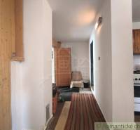 Interior of a cabin with wooden elements and a kitchenette.