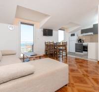 Living room in a holiday apartment with a kitchen and sea view, floor with wood decor.