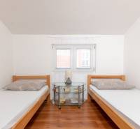 Recreational apartment: Two single beds with a nightstand and a wooden decor floor.