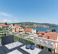 The view from the terrace of the holiday apartment in Ciovo of the sea and surrounding houses with red roofs.