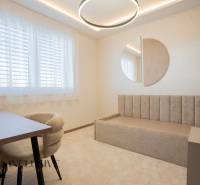 Bright room in a family house with a bed, table, and mirror on the wall.