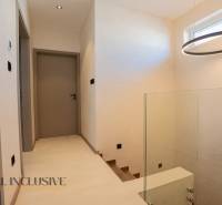 A hallway in a family house with a circular light fixture and wooden doors.