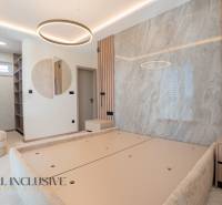 The interior of a family house with light walls, circular lighting, and built-in shelves.