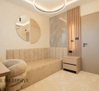 A bright room with a beige sofa, a round mirror, and a table in a family house.
