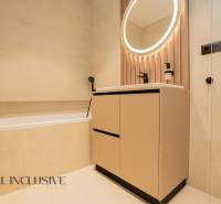 A bathroom with an oval mirror and a bathtub in a family house.