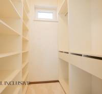Bright dressing room in a family house with shelves and a window.