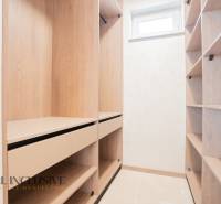 A wardrobe with a wooden decor and storage spaces in a family house.